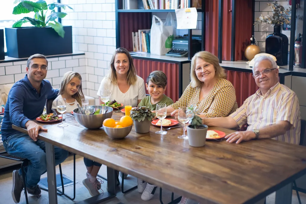 Three generations of a family sharing a meal at a long table.