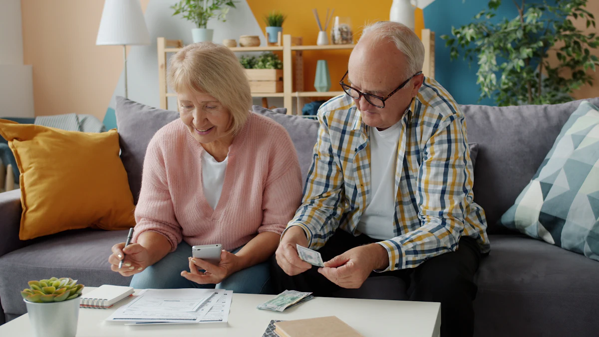 An older couple on a sofa, reviewing papers together at a coffee table.